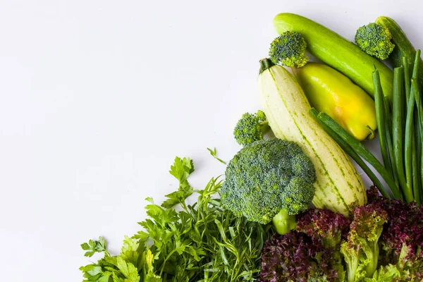 Beyaz arka planda yeşil sebze yaprakları, çiğ tarhun, kabak, lahana ve salatalık.