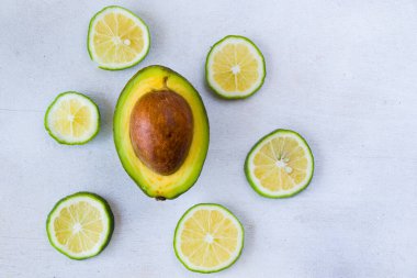 Beyaz arka planda yarım avokado ve limon.