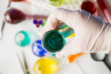 Laboratuvar aletleri, cam eşyalar ve reaktörler, renkli sıvı kimyasal elementler, araştırma teşhisleri, eldivenli doktorlar.