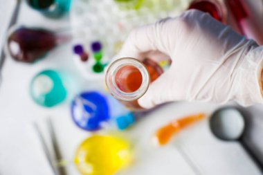 Laboratuvar aletleri, cam eşyalar ve reaktörler, renkli sıvı kimyasal elementler, araştırma teşhisleri, eldivenli doktorlar.