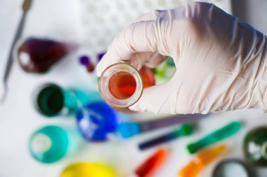 Laboratuvar aletleri, cam eşyalar ve reaktörler, renkli sıvı kimyasal elementler, araştırma teşhisleri, eldivenli doktorlar.