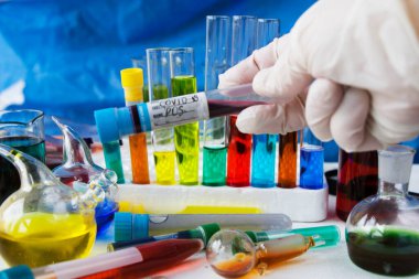 Corona virüsü, Covid. Laboratuvarda, cam ve reaksiyonlarda 19 pozitif kan testi tüpü.