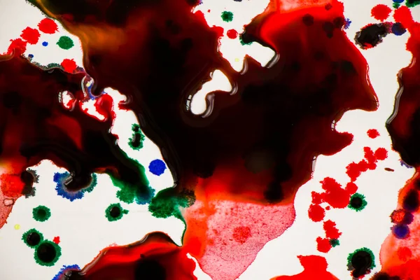 Ink drops on the paper, red, green and blue ink splashes background, painting and drawing