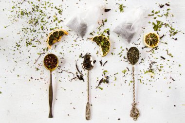 Eski gümüş kaşıklarda, çay poşetlerinde ve çeşitli çay çeşitlerinde çay.