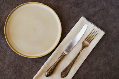 Masa takımı ve bulaşık takımı, tabak, halk, bıçak ve kaşık gri arka planda.