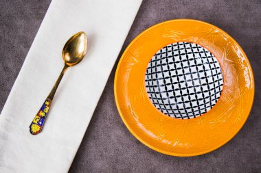 Boş sofra takımı ve bulaşık takımı ayarları ve gri arka planda servis, tabak, kase ve klasik kaşık