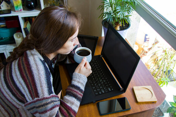 Женщина работает с ноутбуком на рабочем месте, цифровой планшет, мобильный телефон, кофе и заводов в рабочем пространстве, домашняя работа