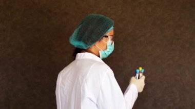 Kan testi tüpü örnekleri doktorların elinde, doktor üniformalı.