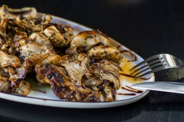 Lokantadaki tabakta mantar yemeği ve yemek, siyah arka plan.