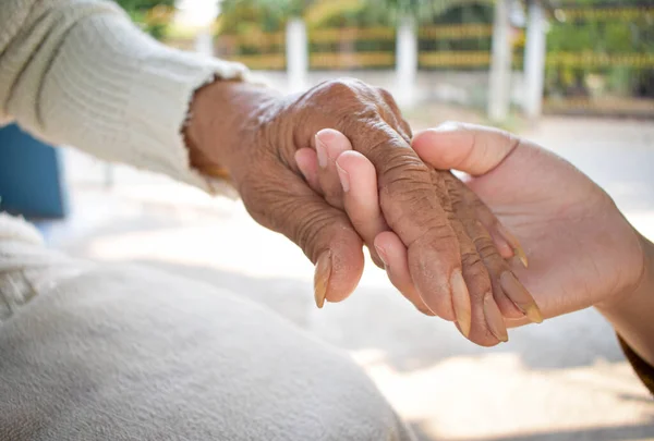 孫娘を閉じる手を握って自宅で病気の祖母の世話をします 家族の愛を支えるライフスタイル — ストック写真