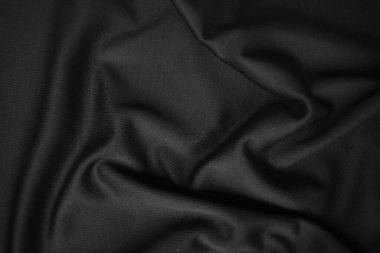 Arkaplan dokusu siyah kumaş. Soyut koyu dalgalı yumuşak. Kumaş kırışmış. Lüks moda tarzı..