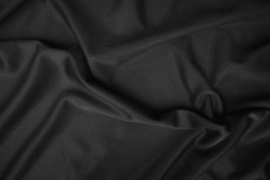 Arkaplan dokusu siyah kumaş. Soyut koyu dalgalı yumuşak. Kumaş kırışmış. Lüks moda tarzı..
