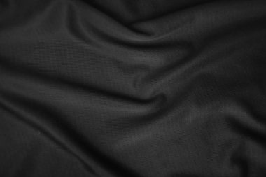 Arkaplan dokusu siyah kumaş. Soyut koyu dalgalı yumuşak. Kumaş kırışmış. Lüks moda tarzı..