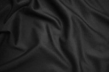 Arkaplan dokusu siyah kumaş. Soyut koyu dalgalı yumuşak. Kumaş kırışmış. Lüks moda tarzı..