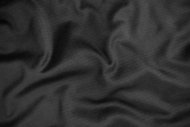 Arkaplan dokusu siyah kumaş. Soyut koyu dalgalı yumuşak. Kumaş kırışmış. Lüks moda tarzı..