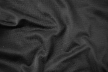 Arkaplan dokusu siyah kumaş. Soyut koyu dalgalı yumuşak. Kumaş kırışmış. Lüks moda tarzı..