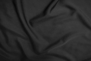 Arkaplan dokusu siyah kumaş. Soyut koyu dalgalı yumuşak. Kumaş kırışmış. Lüks moda tarzı..