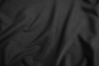 Arkaplan dokusu siyah kumaş. Soyut koyu dalgalı yumuşak. Kumaş kırışmış. Lüks moda tarzı..