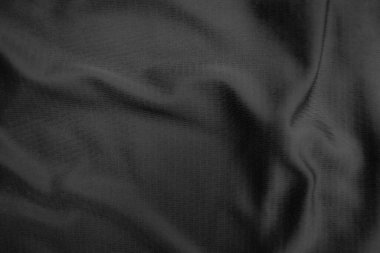 Arkaplan dokusu siyah kumaş. Soyut koyu dalgalı yumuşak. Kumaş kırışmış. Lüks moda tarzı..