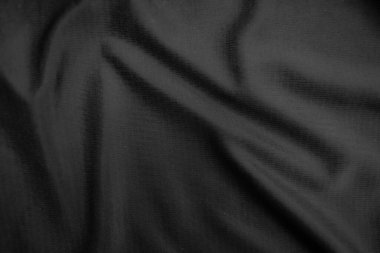 Arkaplan dokusu siyah kumaş. Soyut koyu dalgalı yumuşak. Kumaş kırışmış. Lüks moda tarzı..