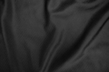 Arkaplan dokusu siyah kumaş. Soyut koyu dalgalı yumuşak. Kumaş kırışmış. Lüks moda tarzı..