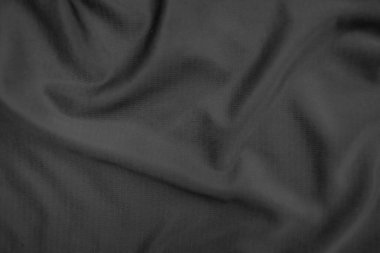 Arkaplan dokusu siyah kumaş. Soyut koyu dalgalı yumuşak. Kumaş kırışmış. Lüks moda tarzı..