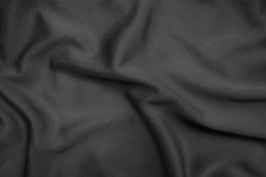 Arkaplan dokusu siyah kumaş. Soyut koyu dalgalı yumuşak. Kumaş kırışmış. Lüks moda tarzı..