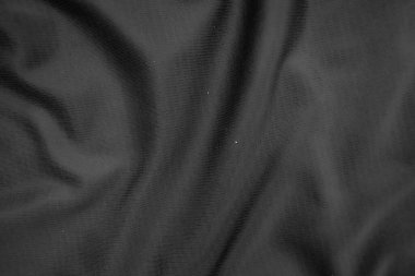 Arkaplan dokusu siyah kumaş. Soyut koyu dalgalı yumuşak. Kumaş kırışmış. Lüks moda tarzı..