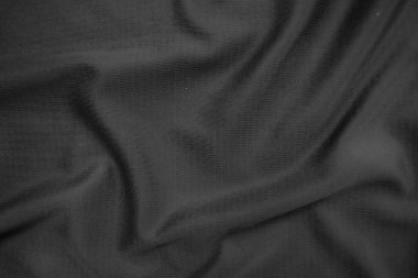 Arkaplan dokusu siyah kumaş. Soyut koyu dalgalı yumuşak. Kumaş kırışmış. Lüks moda tarzı..