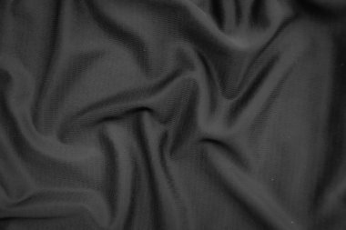 Arkaplan dokusu siyah kumaş. Soyut koyu dalgalı yumuşak. Kumaş kırışmış. Lüks moda tarzı..