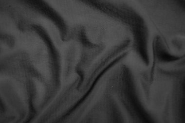 Arkaplan dokusu siyah kumaş. Soyut koyu dalgalı yumuşak. Kumaş kırışmış. Lüks moda tarzı..