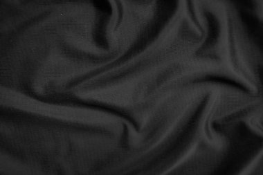 Arkaplan dokusu siyah kumaş. Soyut koyu dalgalı yumuşak. Kumaş kırışmış. Lüks moda tarzı..
