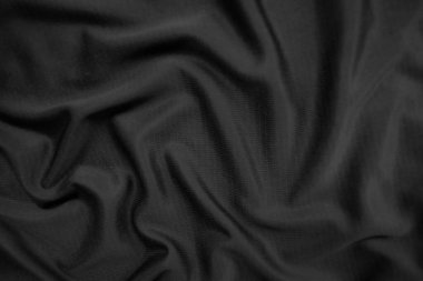 Arkaplan dokusu siyah kumaş. Soyut koyu dalgalı yumuşak. Kumaş kırışmış. Lüks moda tarzı..