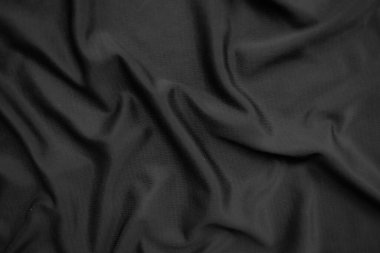 Arkaplan dokusu siyah kumaş. Soyut koyu dalgalı yumuşak. Kumaş kırışmış. Lüks moda tarzı..