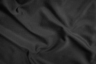 Arkaplan dokusu siyah kumaş. Soyut koyu dalgalı yumuşak. Kumaş kırışmış. Lüks moda tarzı..