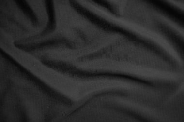 Arkaplan dokusu siyah kumaş. Soyut koyu dalgalı yumuşak. Kumaş kırışmış. Lüks moda tarzı..