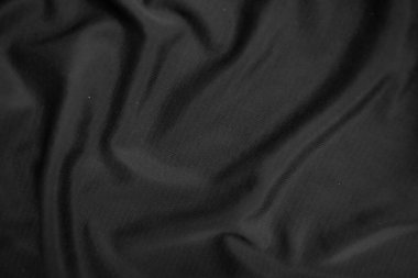 Arkaplan dokusu siyah kumaş. Soyut koyu dalgalı yumuşak. Kumaş kırışmış. Lüks moda tarzı..