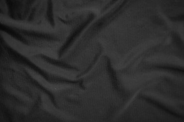 Arkaplan dokusu siyah kumaş. Soyut koyu dalgalı yumuşak. Kumaş kırışmış. Lüks moda tarzı..