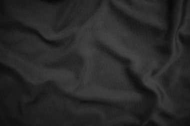 Arkaplan dokusu siyah kumaş. Soyut koyu dalgalı yumuşak. Kumaş kırışmış. Lüks moda tarzı..