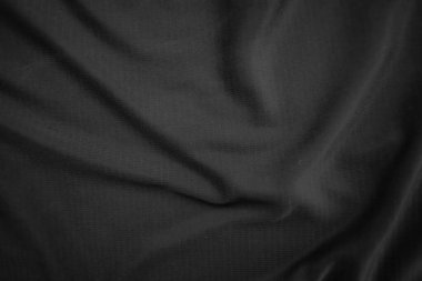 Arkaplan dokusu siyah kumaş. Soyut koyu dalgalı yumuşak. Kumaş kırışmış. Lüks moda tarzı..