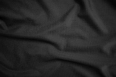 Arkaplan dokusu siyah kumaş. Soyut koyu dalgalı yumuşak. Kumaş kırışmış. Lüks moda tarzı..