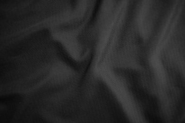 Arkaplan dokusu siyah kumaş. Soyut koyu dalgalı yumuşak. Kumaş kırışmış. Lüks moda tarzı..