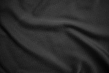 Arkaplan dokusu siyah kumaş. Soyut koyu dalgalı yumuşak. Kumaş kırışmış. Lüks moda tarzı..