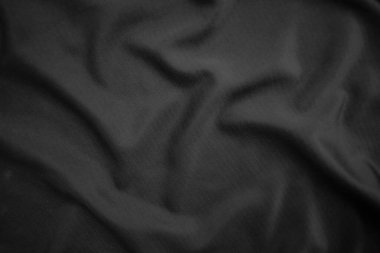 Arkaplan dokusu siyah kumaş. Soyut koyu dalgalı yumuşak. Kumaş kırışmış. Lüks moda tarzı..