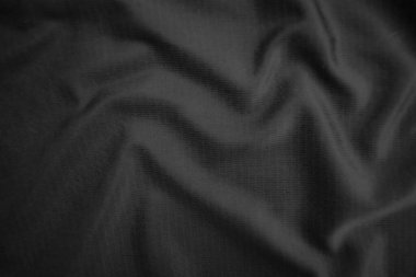 Arkaplan dokusu siyah kumaş. Soyut koyu dalgalı yumuşak. Kumaş kırışmış. Lüks moda tarzı..