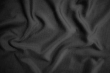 Arkaplan dokusu siyah kumaş. Soyut koyu dalgalı yumuşak. Kumaş kırışmış. Lüks moda tarzı..