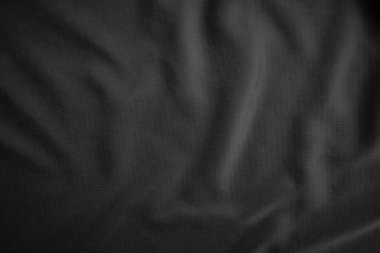 Arkaplan dokusu siyah kumaş. Soyut koyu dalgalı yumuşak. Kumaş kırışmış. Lüks moda tarzı..