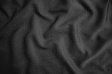 Arkaplan dokusu siyah kumaş. Soyut koyu dalgalı yumuşak. Kumaş kırışmış. Lüks moda tarzı..