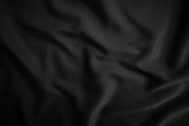 Arkaplan dokusu siyah kumaş. Soyut koyu dalgalı yumuşak. Kumaş kırışmış. Lüks moda tarzı..