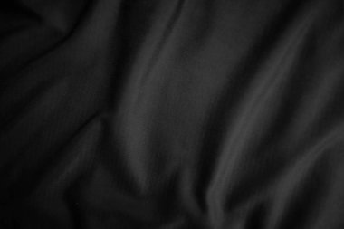 Arkaplan dokusu siyah kumaş. Soyut koyu dalgalı yumuşak. Kumaş kırışmış. Lüks moda tarzı..